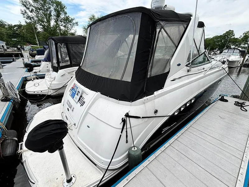 Slide: The Image of 2004 Chaparral 350 Signature boat docked at a marina, featuring a sleek design and covered cockpit. - 2
