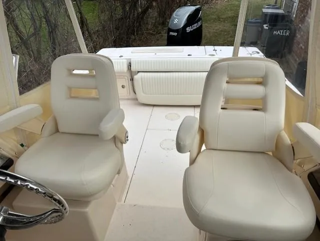 Slide: The Image of 2008 Grady-White Gulfstream 232 boat interior with two white seats and Suzuki engine. - 6