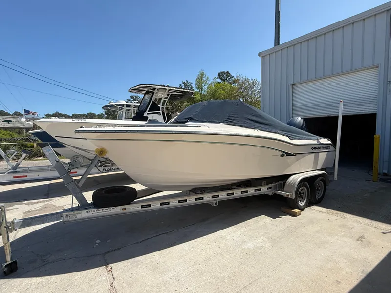 Slide: The Image of 2011 Grady-White Freedom 192 boat on trailer, covered, parked outside a garage. - 8