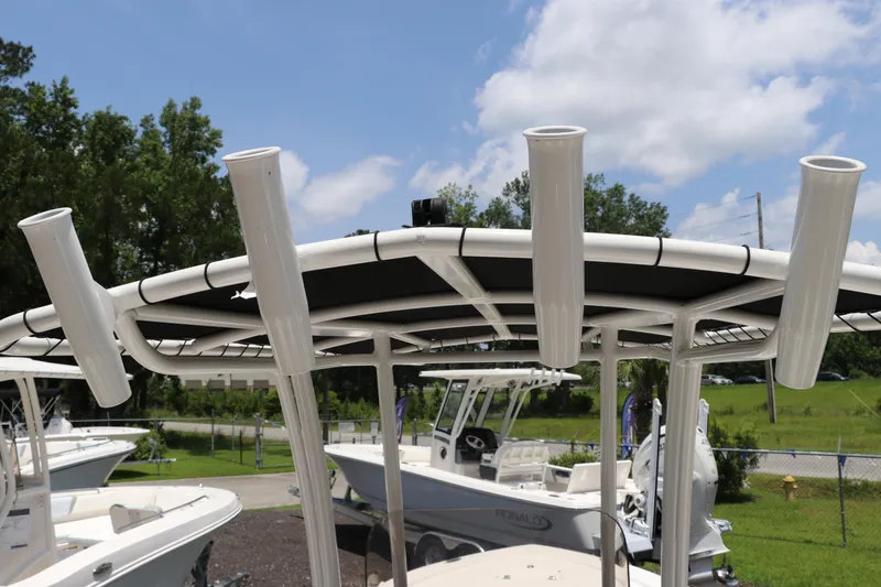 Slide: The Image of 2025 Robalo 206 Cayman boat with rod holders and canopy, parked outdoors. - 13