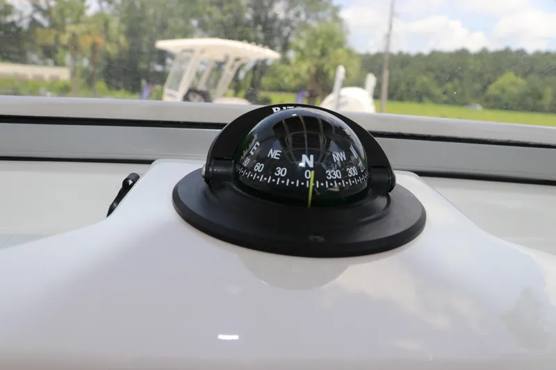 Slide: The Image of Compass on 2025 Robalo 206 Cayman boat dashboard, with outdoor background. - 16