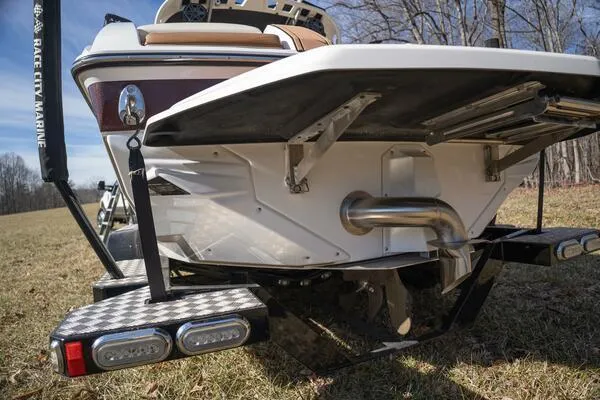 Slide: The Image of 2017 Correct Craft Super Air Nautique GS boat rear view, showcasing exhaust and platform. - 25