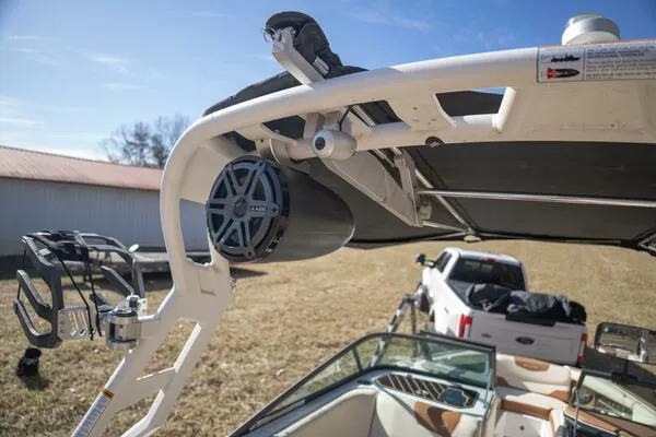 Slide: The Image of 2017 Correct Craft Super Air Nautique GS boat with speaker and canopy, parked near a truck. - 30