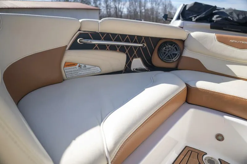 Slide: The Image of 2017 Correct Craft Super Air Nautique GS interior with tan and white seating, speaker, and wood accents. - 34