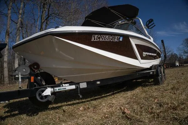 Slide: The Image of 2017 Correct Craft Super Air Nautique GS boat on trailer, parked on grass. - 47