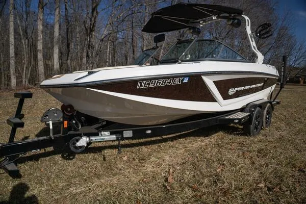 Slide: The Image of 2017 Correct Craft Super Air Nautique GS boat on trailer, parked on grass. - 48