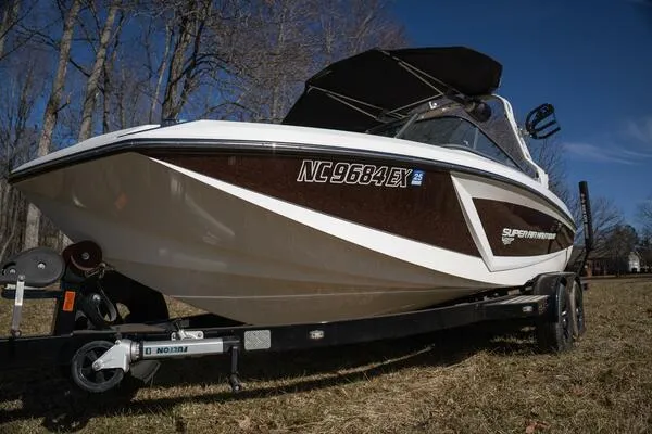 Slide: The Image of 2017 Correct Craft Super Air Nautique GS boat on trailer in wooded area. - 49