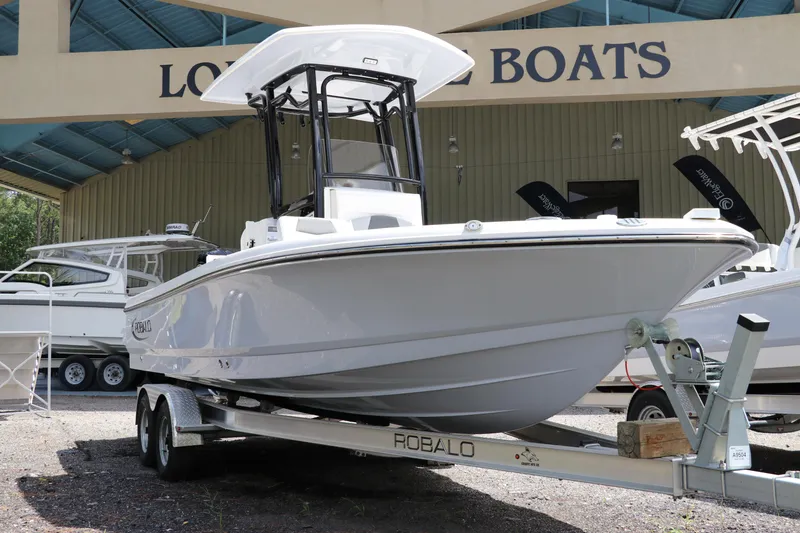 The Image of 2025 Robalo 226 Cayman boat on trailer at dealership, showcasing sleek design. - 0