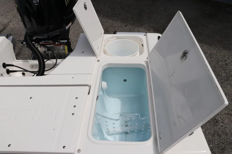 Slide: The Image of 2025 Robalo 226 Cayman boat with open storage compartments and engine view. - 13