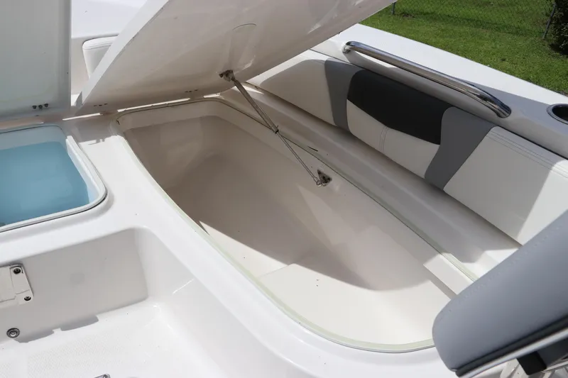 Slide: The Image of 2025 Robalo 226 Cayman boat storage compartment with open hatch and seating area. - 33