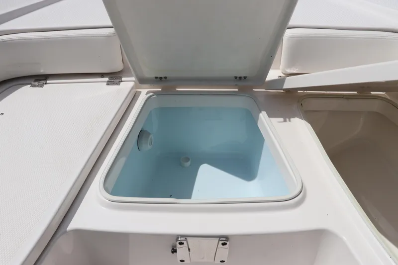Slide: The Image of 2025 Robalo 226 Cayman boat storage compartment with open lid. - 34