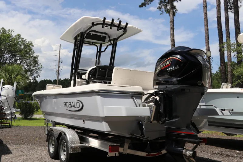 Slide: The Image of 2025 Robalo 226 Cayman boat on trailer with Yamaha engine, parked outdoors. - 6