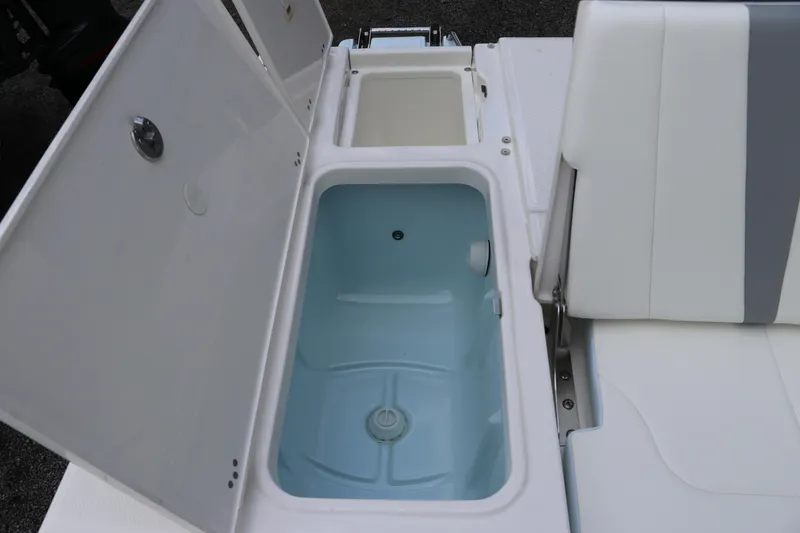 Slide: The Image of 2025 Robalo 226 Cayman boat storage compartments with open lids and seating. - 10