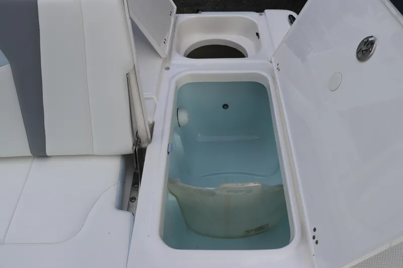 Slide: The Image of 2025 Robalo 226 Cayman boat storage compartment with open hatch and seating. - 13