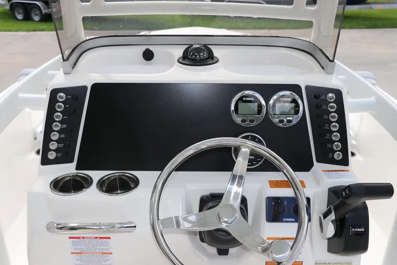 Slide: The Image of 2025 Robalo 226 Cayman boat dashboard with steering wheel and Yamaha controls. - 22