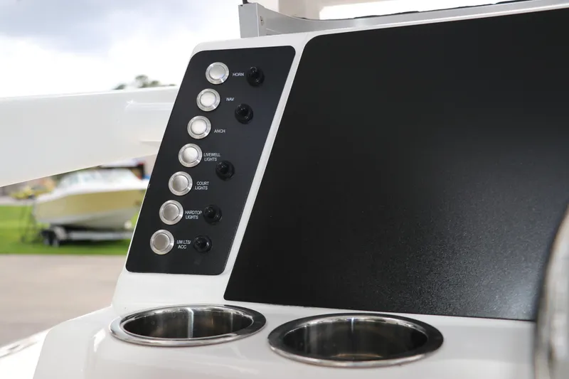 Slide: The Image of Control panel of 2025 Robalo 226 Cayman boat with cup holders and switches. - 24