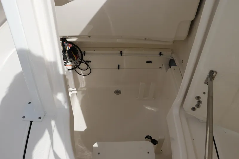Slide: The Image of Interior view of 2025 Robalo 226 Cayman boat, showcasing storage compartment and wiring. - 29