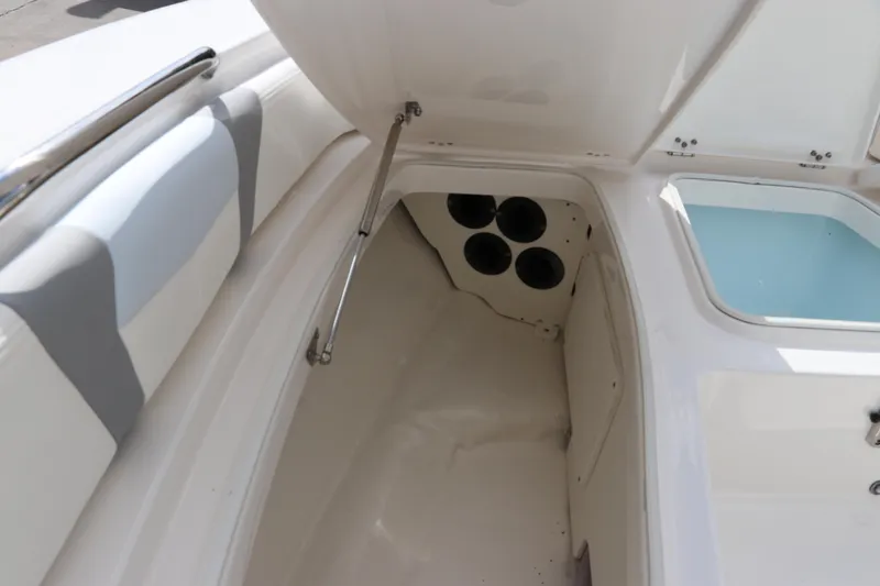 Slide: The Image of 2025 Robalo 226 Cayman boat storage compartment with open hatch and seating area. - 34