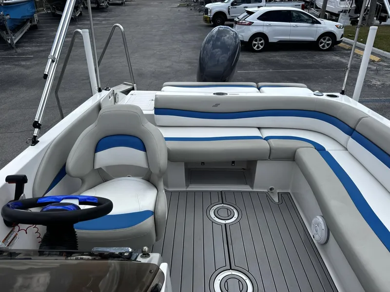 Slide: The Image of 2020 Starcraft MDX 211 OB boat interior with blue and white seating, docked in a marina. - 10