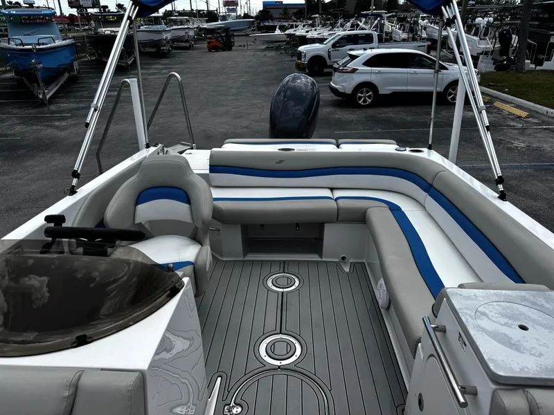 Slide: The Image of 2020 Starcraft MDX 211 OB boat interior with seating and steering wheel, parked in a marina. - 9