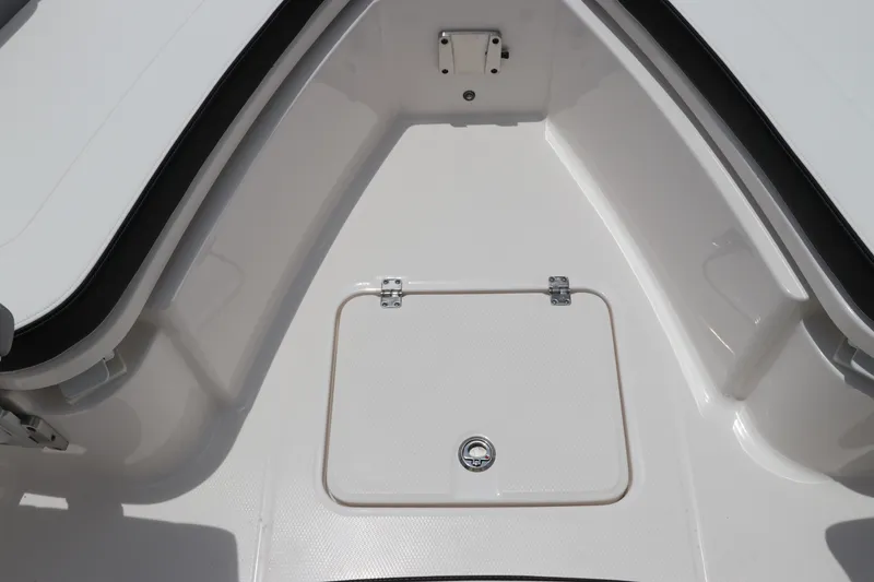 Slide: The Image of 2024 Robalo R230 Center Console boat storage compartment, white interior, open hatch. - 32