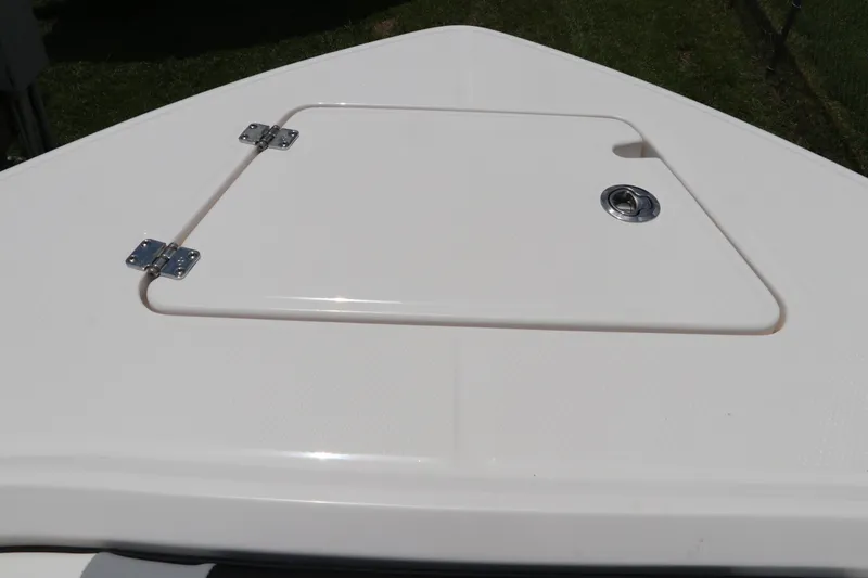 Slide: The Image of 2024 Robalo R230 Center Console boat hatch detail, white surface with metal hinges. - 34