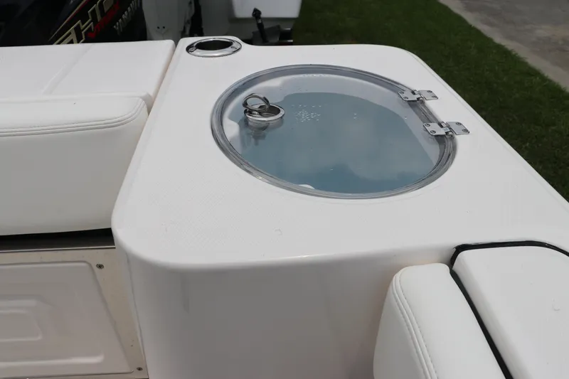 Slide: The Image of 2024 Robalo R230 Center Console livewell with transparent lid and cup holder. - 9