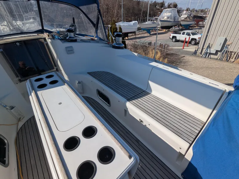 Slide: The Image of Cockpit of 1996 Jeanneau 45.1 sailboat with seating and cup holders, docked in a marina. - 13