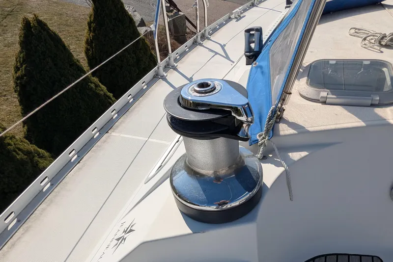 Slide: The Image of Deck of 1996 Jeanneau 45.1 sailboat featuring a winch and blue sail cover. - 15