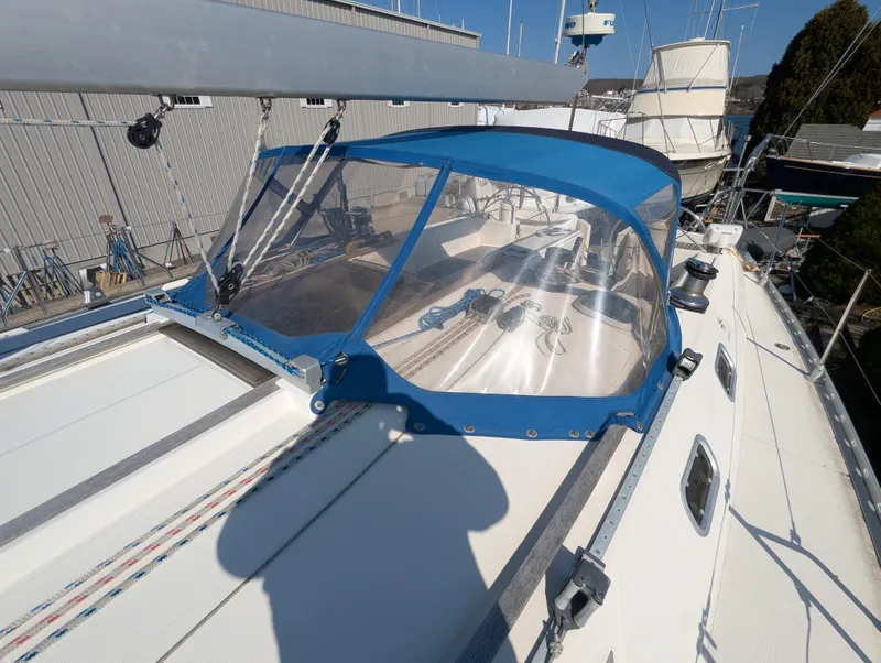 Slide: The Image of 1996 Jeanneau 45.1 sailboat with blue canopy, docked in a marina. - 20