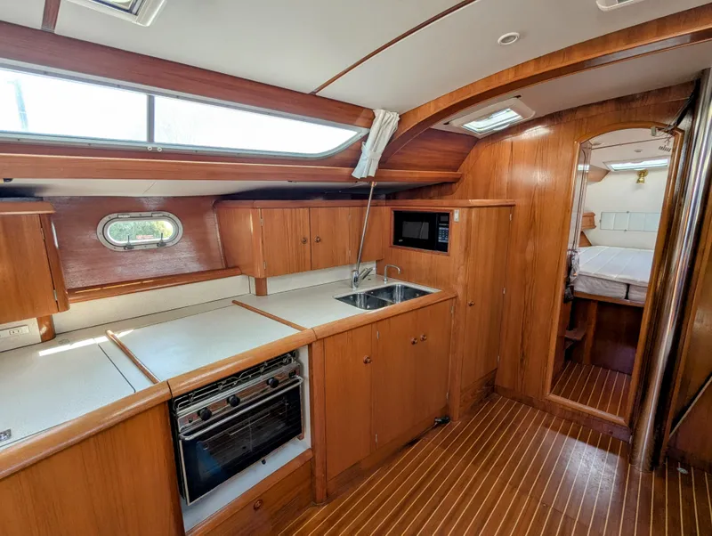 Slide: The Image of Interior of 1996 Jeanneau 45.1 yacht with wooden cabinetry and modern kitchen amenities. - 24