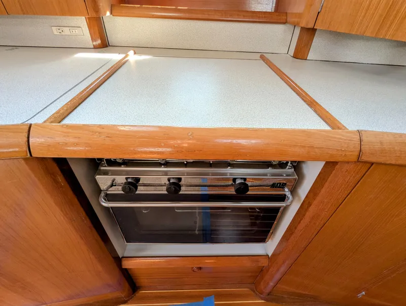 Slide: The Image of 1996 Jeanneau 45.1 yacht kitchen with built-in oven and wooden cabinetry. - 26