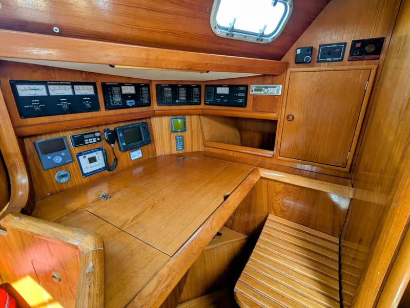 Slide: The Image of Navigation station of 1996 Jeanneau 45.1 sailboat with wooden interior and control panels. - 28