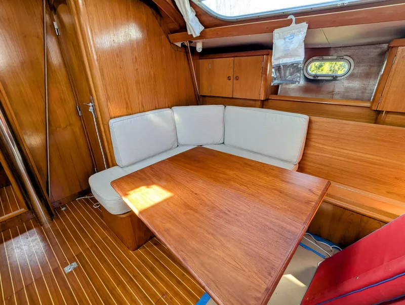 Slide: The Image of Interior of 1996 Jeanneau 45.1 sailboat with wooden dining area and cushioned seating. - 30
