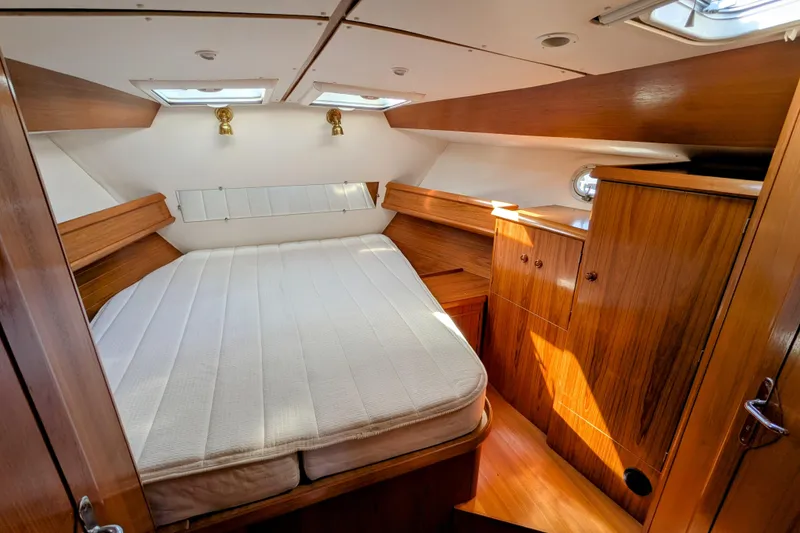 Slide: The Image of Cozy cabin interior of 1996 Jeanneau 45.1 sailboat with wooden furnishings and double bed. - 32