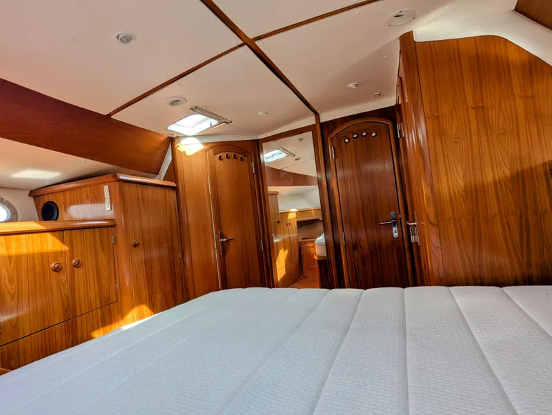 Slide: The Image of Interior of 1996 Jeanneau 45.1 yacht, featuring wooden cabinetry and a cozy sleeping area. - 34