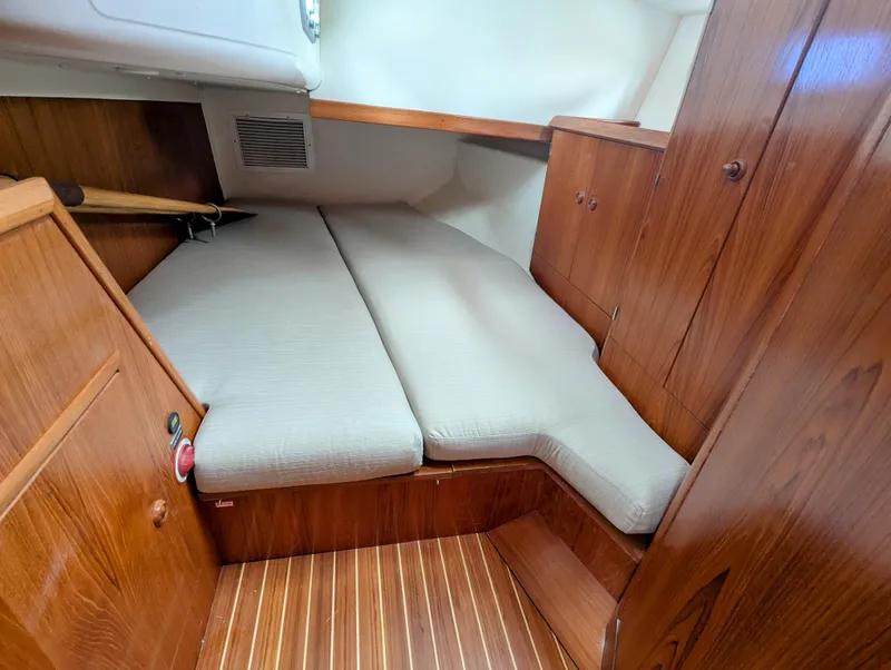 Slide: The Image of 1996 Jeanneau 45.1 yacht cabin with wooden interior and cushioned bed. - 36