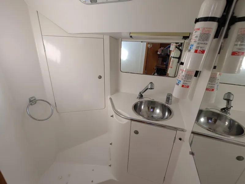 Slide: The Image of Bathroom interior of 1996 Jeanneau 45.1 yacht with sink, mirror, and fire extinguisher. - 40