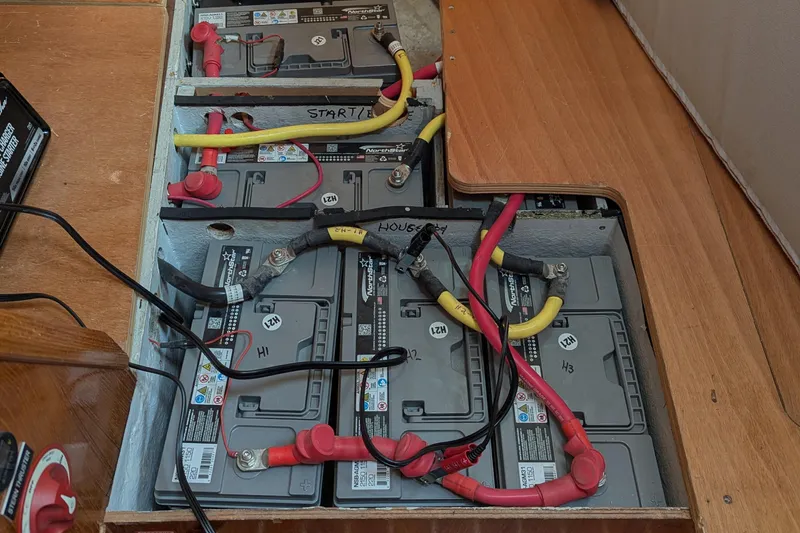 Slide: The Image of Battery compartment of a 1996 Jeanneau 45.1 sailboat with multiple connected batteries. - 44