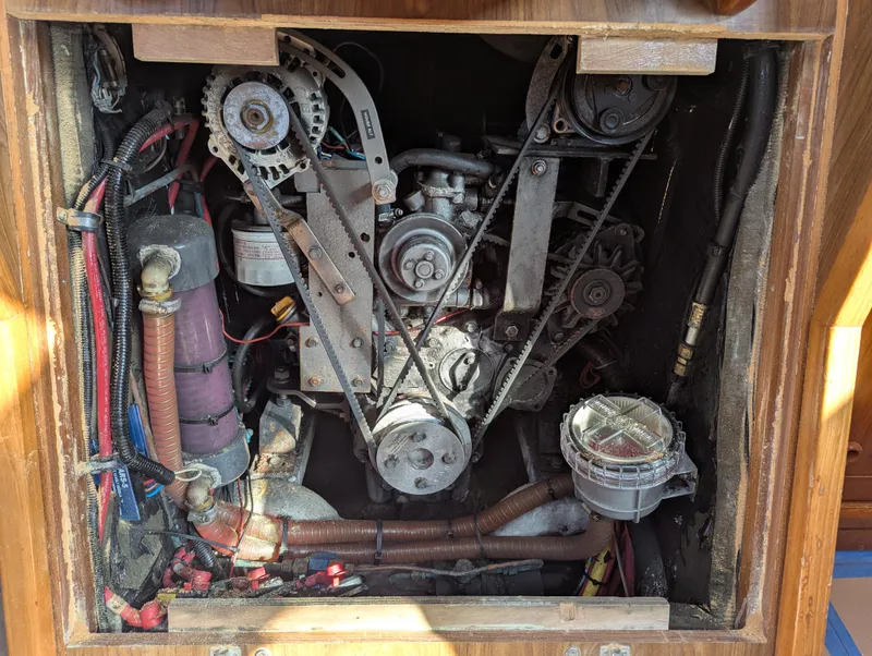 Slide: The Image of Engine compartment of a 1996 Jeanneau 45.1 sailboat, showing belts and mechanical components. - 46
