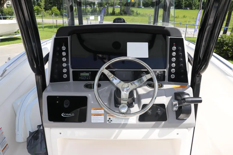 Slide: The Image of 2024 Robalo R230 Center Console boat dashboard with steering wheel and controls. - 19