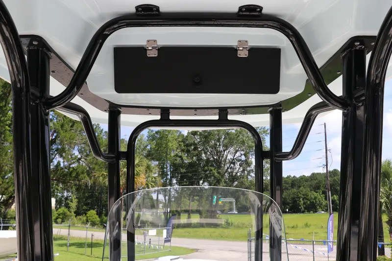 Slide: The Image of 2024 Robalo R230 Center Console T-top interior with clear windshield and outdoor view. - 27