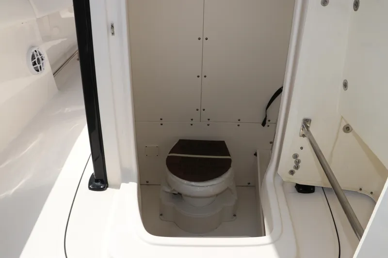 Slide: The Image of 2024 Robalo R230 Center Console boat interior with compact marine toilet. - 30
