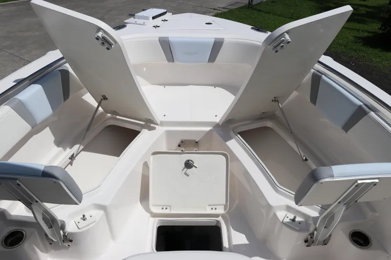 Slide: The Image of 2024 Robalo R230 Center Console boat with open storage compartments and seating. - 33