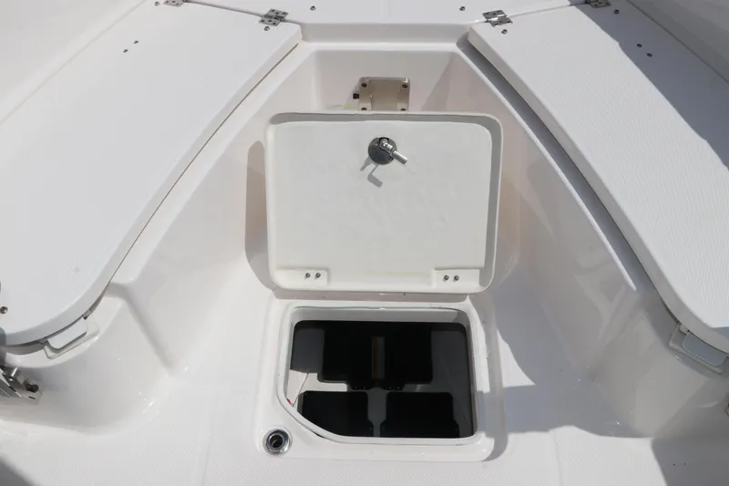 Slide: The Image of 2024 Robalo R230 Center Console boat storage compartment with open hatch. - 34