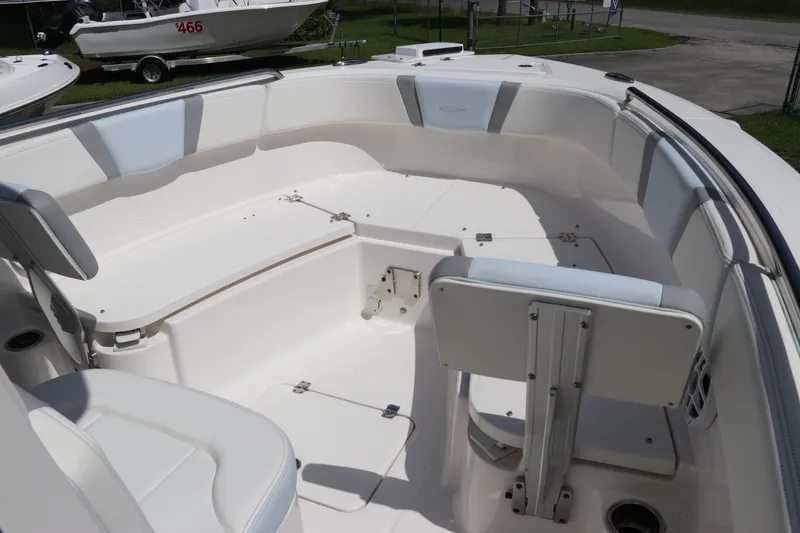 Slide: The Image of 2024 Robalo R230 Center Console boat interior with white seating and storage compartments. - 37