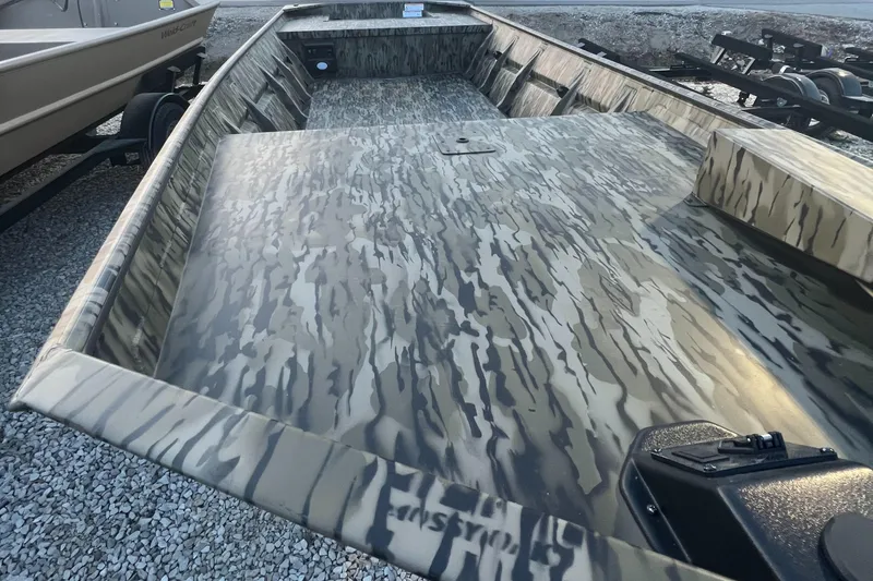 Slide: The Image of 2025 SeaArk 1648 MV Special boat with camouflage design on gravel surface. - 4