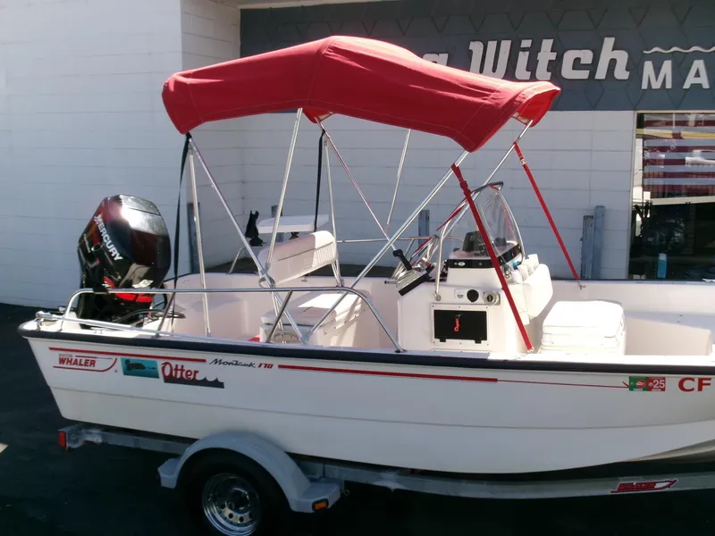 Slide: The Image of 2003 Boston Whaler 170 Montauk boat with red canopy on trailer. - 20
