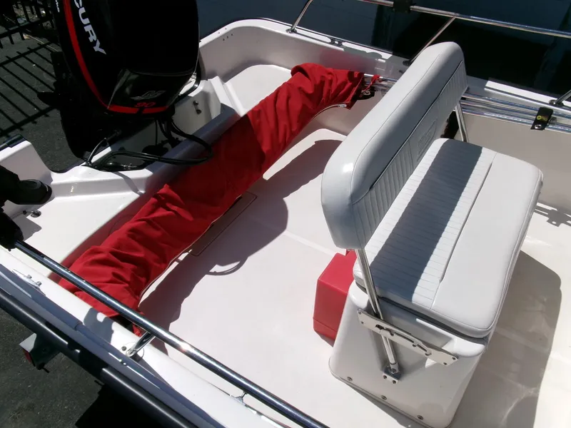 Slide: The Image of 2003 Boston Whaler 170 Montauk interior with seating and Mercury engine. - 21