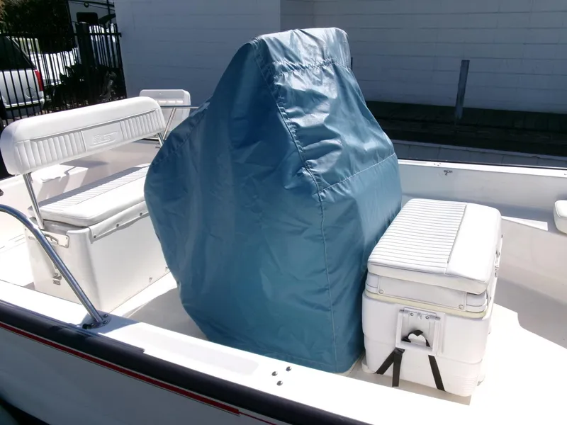 Slide: The Image of 2003 Boston Whaler 170 Montauk boat interior with blue console cover and seating. - 22